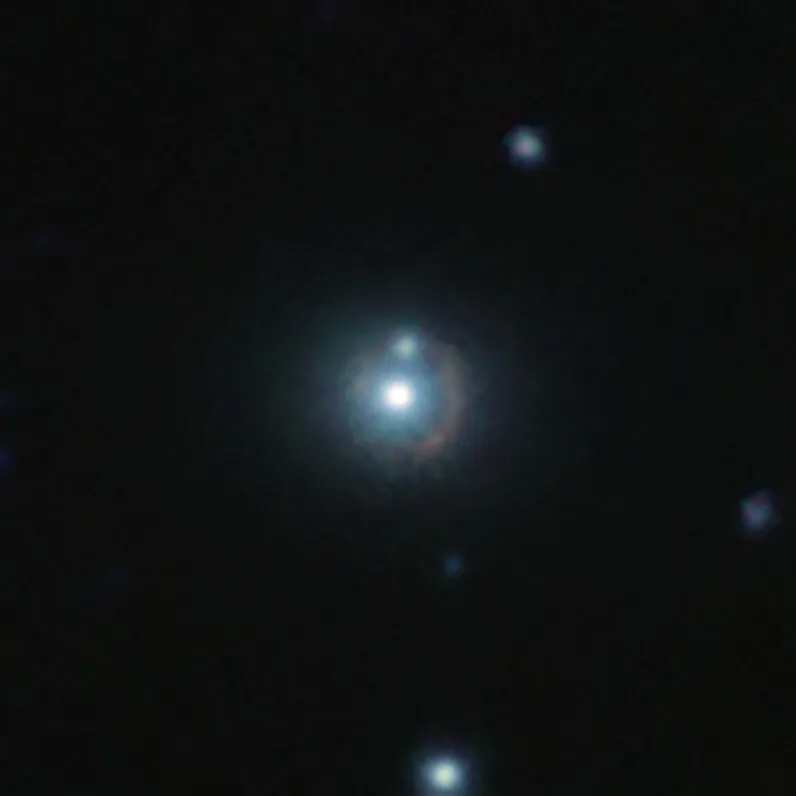 这张红外线影像显示遥远的星系9io9，可以看到它是一条围绕着明亮的附近星系弯曲的微红色弧线。这个附近的明亮星系就像一个重力透镜，它的质量使周围的时空发生了弯曲，因此扭曲了背景中来自9io9星系的光线。此彩色影像是由欧南天文台（ESO）位于智利的可见光和红外巡天望远镜（VISTA），和位于夏威夷的加法夏望远镜（CFHT）拍摄的红外线影像组合而成。This infrared image shows the distant galaxy 9io9, seen here as a reddish arc curved around a bright nearby galaxy. This nearby galaxy acts as a gravitational lens: its mass curves spacetime around it, bending lightrays coming from 9io9 in the background, hence its distorted shape. This color view results from combining infrared images taken with ESO’s Visible and Infrared Survey Telescope for Astronomy (VISTA) in Chile and the Canada France Hawaii Telescope (CFHT) in the US. Credit: ESO/J. Geach et al.