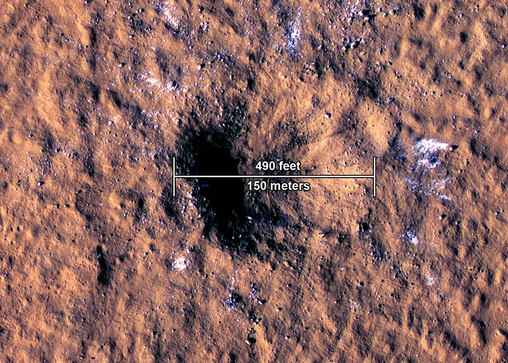 从NASA火星侦察轨道卫星（MRO）上的高解析度成像科学设备（HiRISE相机）所拍摄火星上一个撞击坑的边缘，可看到巨石大小的水冰块。 该陨石坑位于亚马逊平原地区，于2021年12月24日被流星体撞击，形成一个约150公尺宽的陨石坑。图片来源：NASA/JPL-Caltech/University of Arizona