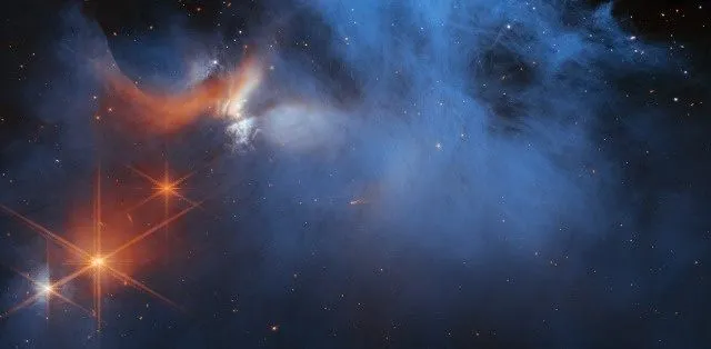 韦伯太空望远镜 (JWST) 获得的原恒星（左上角的橙色区域；与本研究中的原恒星不同）假色图像。JWST使用红外仪器研究原恒星如何形成冰（蓝色）的化学成分。图片来源：NASA、ESA、CSA