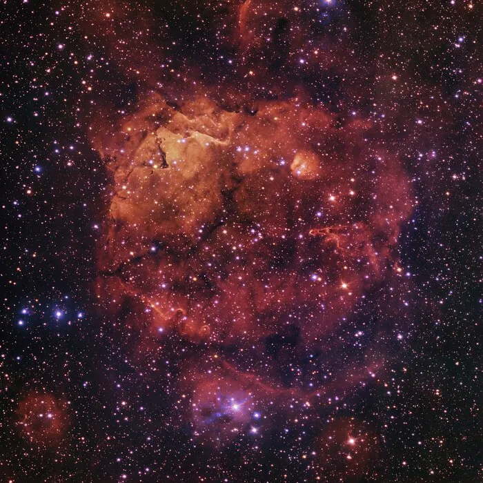 由VST巡天望远镜所拍摄的Sh2-284微笑猫咪星云。This image from ESO’s VLT Survey Telescope shows Sh2-284, a nebula some 15,000 light-years away in the constellation of Monoceros. Image credit: ESO / VPHAS+ Team / CASU.